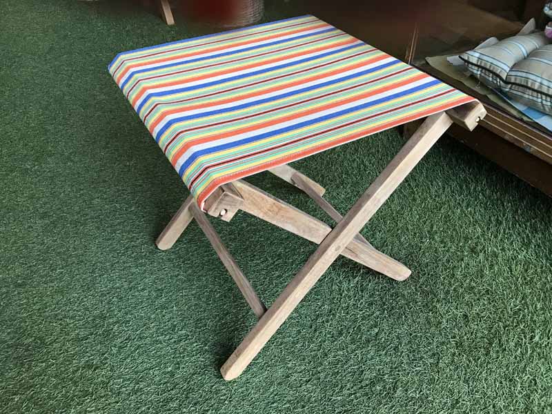 Folding Wooden Stool with dark blue, beige, orange, yellow and green striped seat   